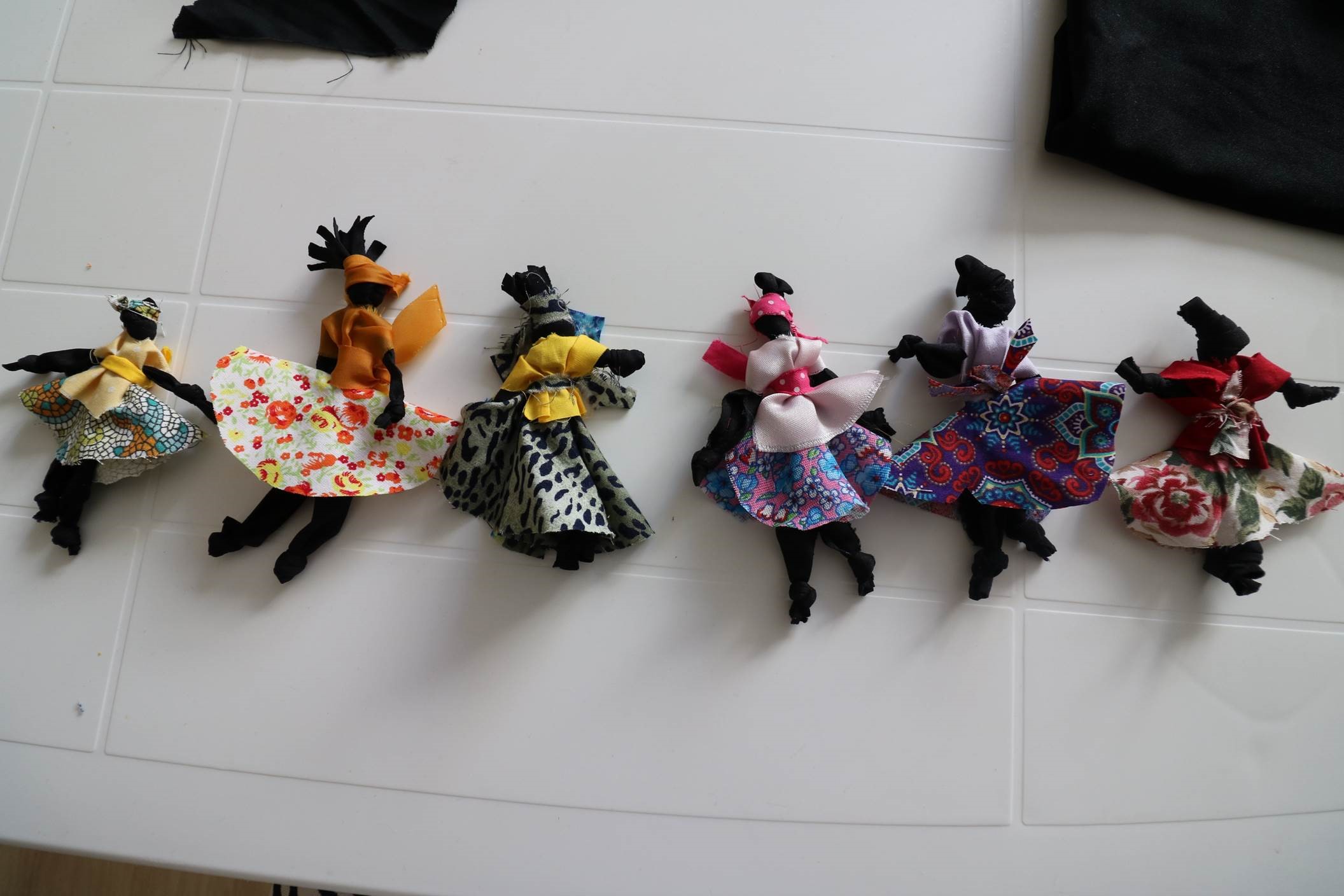 #Paracegover Na imagem estão seis bonecas feitas com retalhos de tecidos.