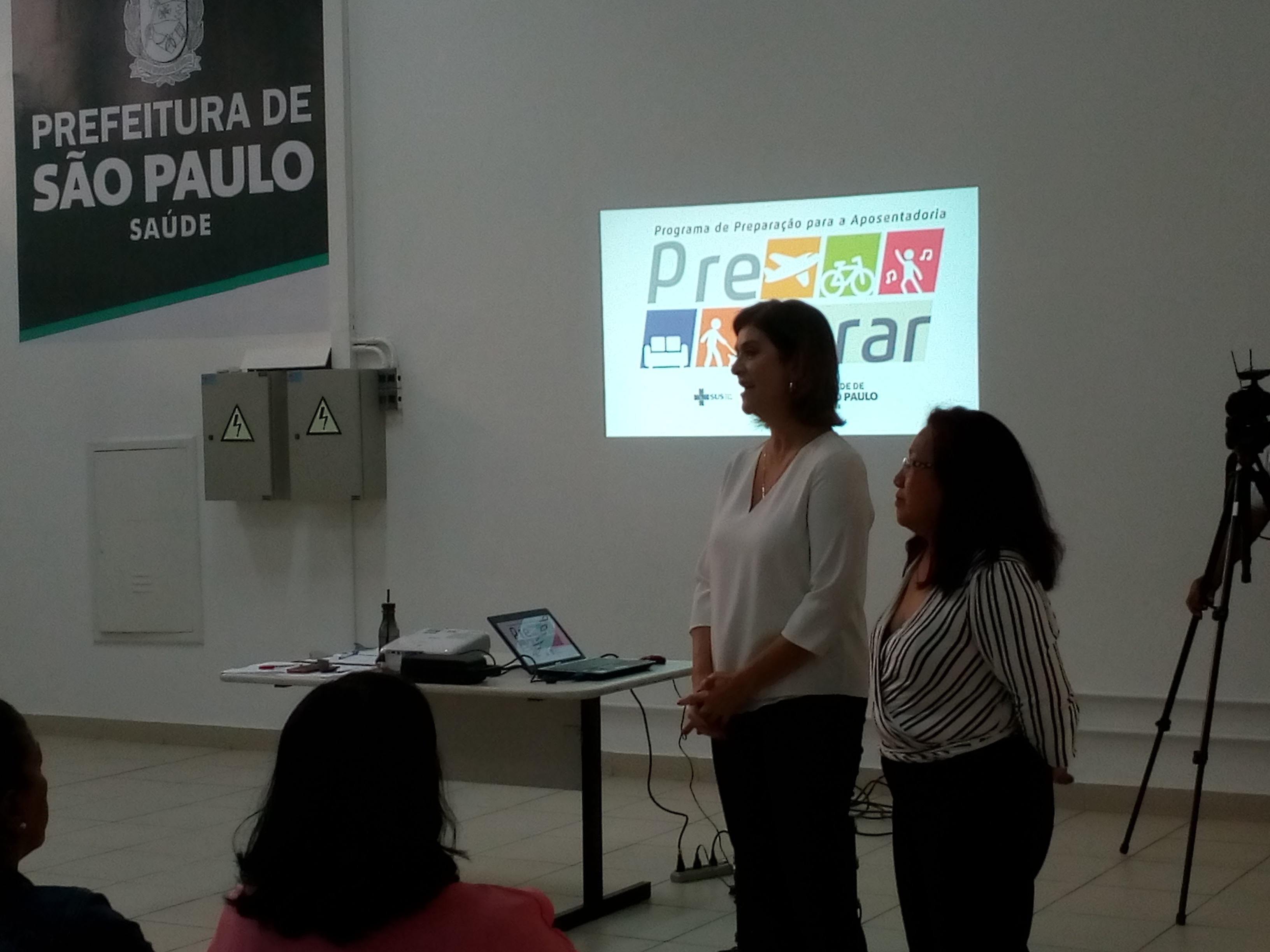 # Paracegover Na imagem estão Jane Abraão e Gilse Assami lado a lado conversando com os participantes do evento