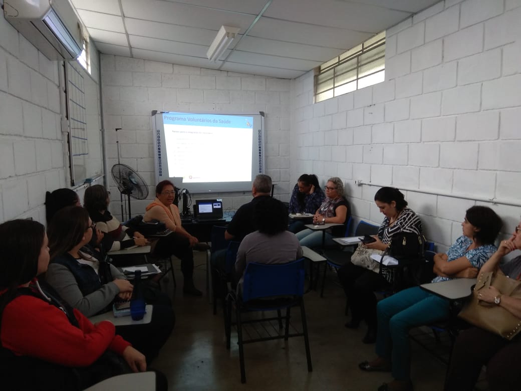 #Paracegover Na imagem; a Diretora da Divisão de Qualidade de Vida no Trabalho, Gilse Assami, está sentada conversando com a equipe de gestão de pessoas da Coordenadoria Norte