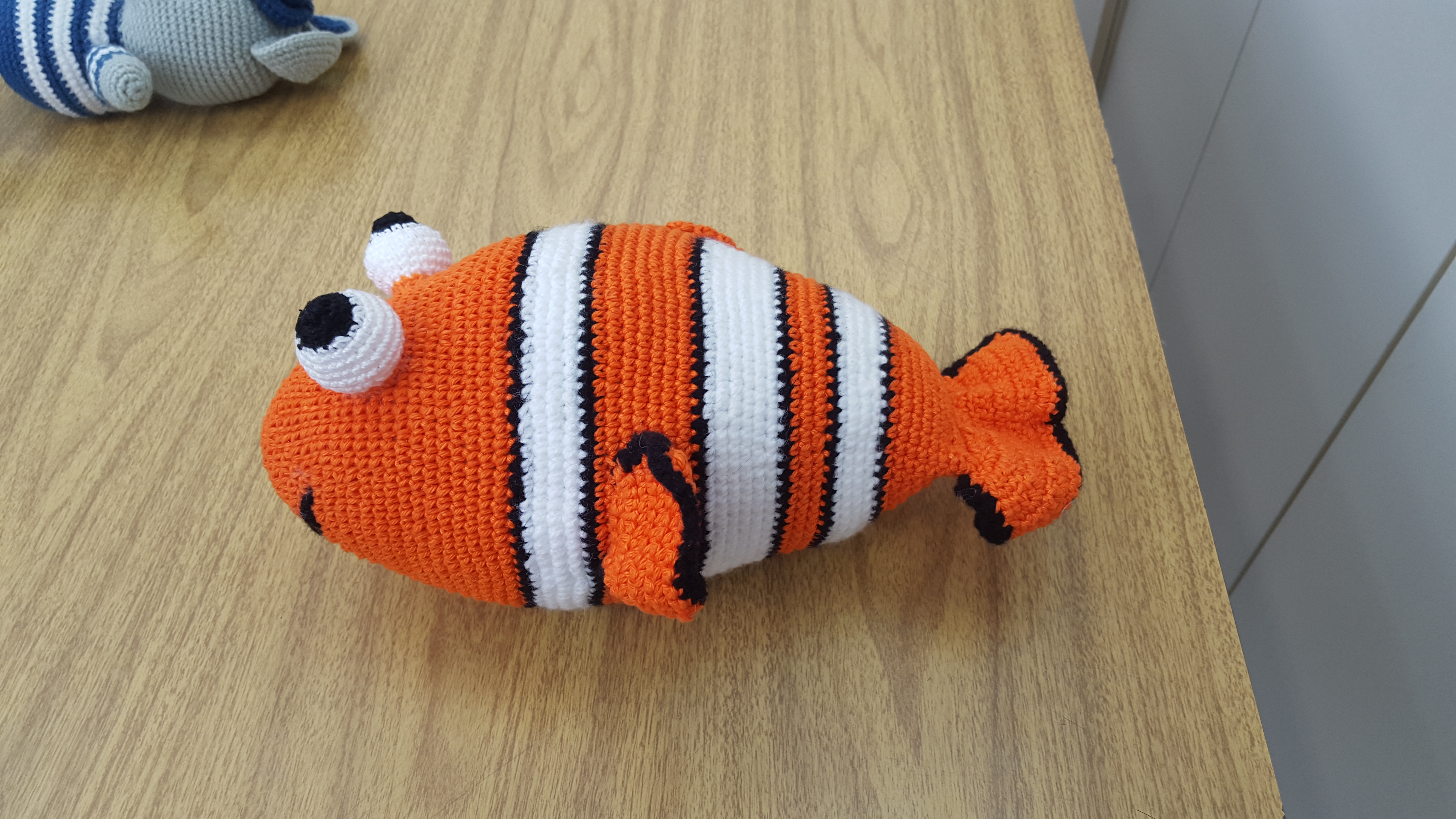 #Paracegover Na imagem está o peixe Nemo, feito em crochê, personagem da animação Procurando Nemo