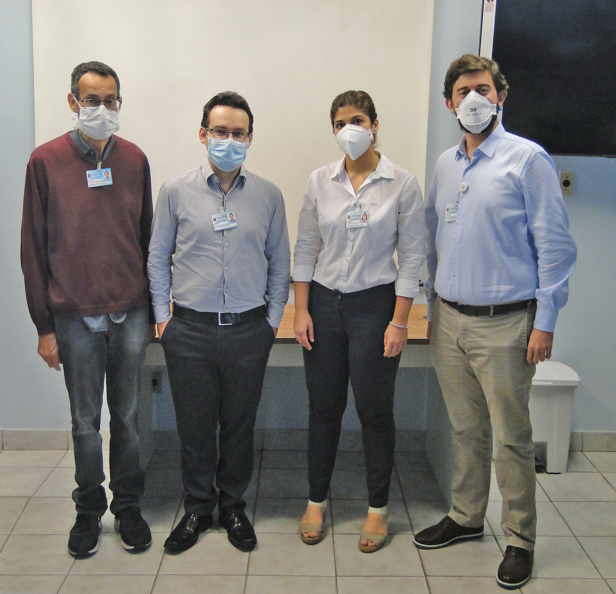Foto com quatro integrantes da equipe de neurocirurgia do HSPM, dois homens, uma mulher e outro homem no canto direito