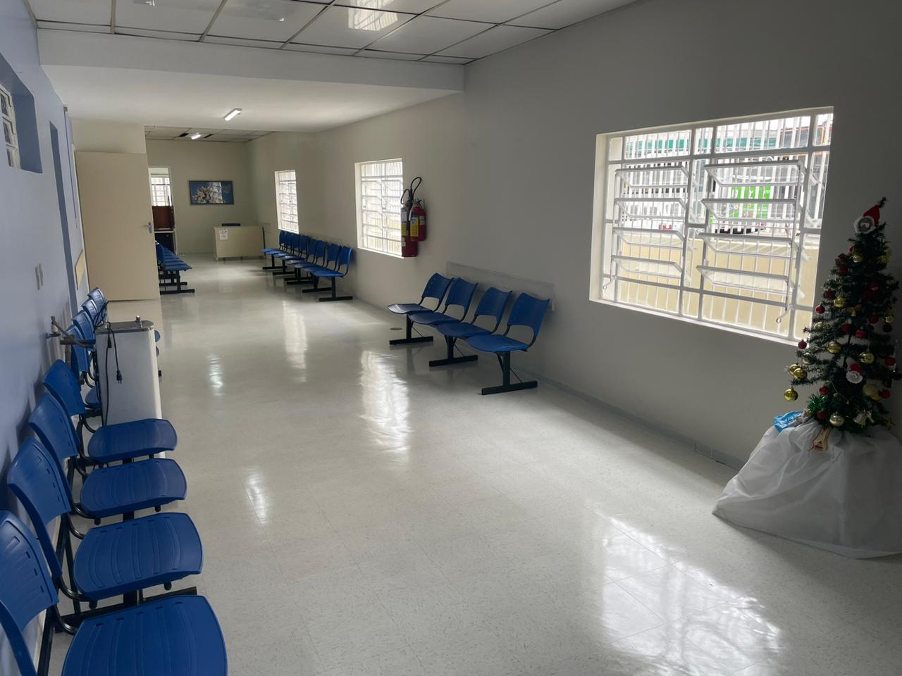 Imagem panorâmica do corredor do Ambulatório Lapa, com cadeiras encostadas na parede, mostrando o novo piso