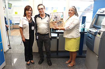 Fotografia do funcionário premiado recebendo a cesta de dia dos pais