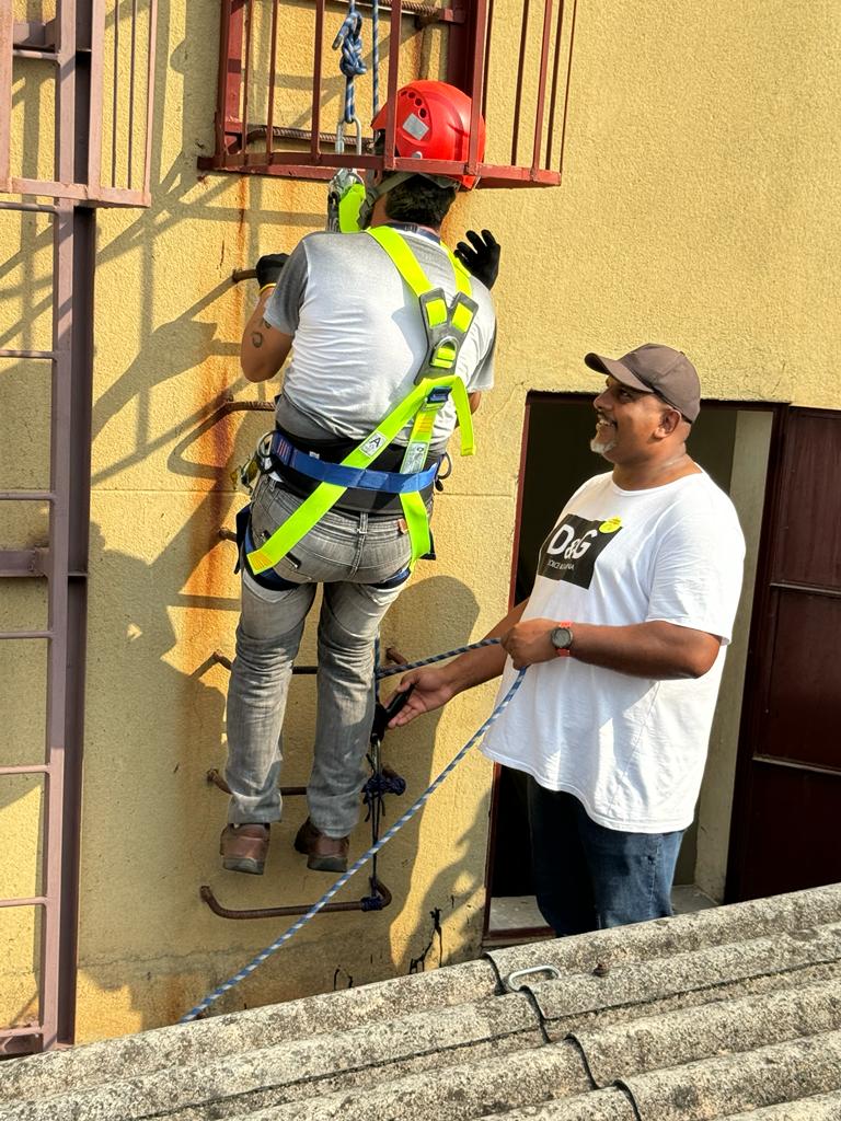 Fotografia na área externa do HSPM, na qual os servidores aparecem equipados com equipamentos de segurança e realizam uma simulado de procedimento de segurança, ao subirem pela escada de emergência