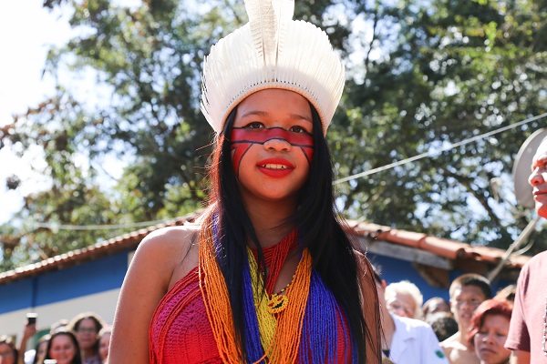 #PraCegoVer: mulher indígena desfila com pintura no corpo, cocar e roupa confeccionada pelas indígenas da aldeia