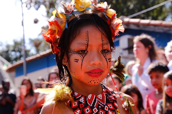 #PraCegoVer: criança indígena desfila com pintura no corpo, cocar e roupa confeccionada pelas indígenas da aldeia