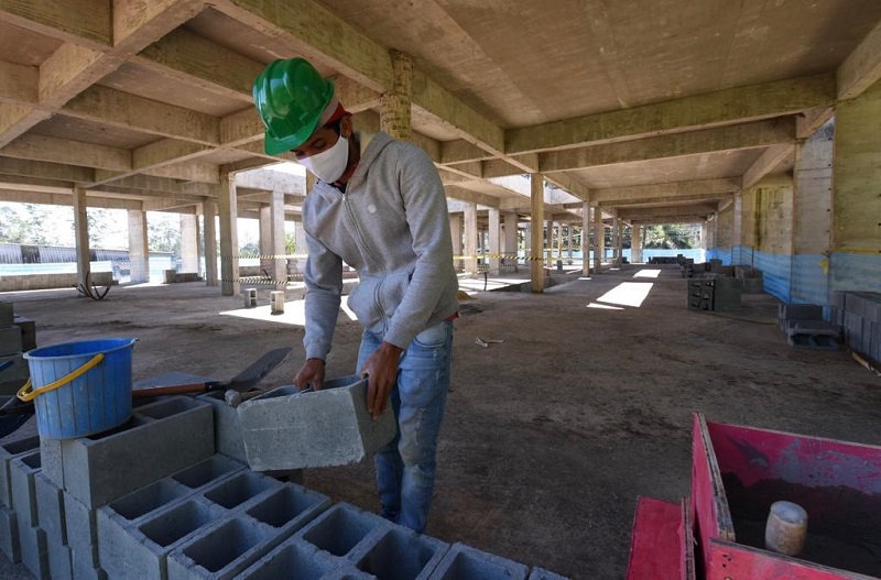 #PraCegoVer: imagem mostra um profissional da construção civil trabalhando na obra da UPA Parelheiros