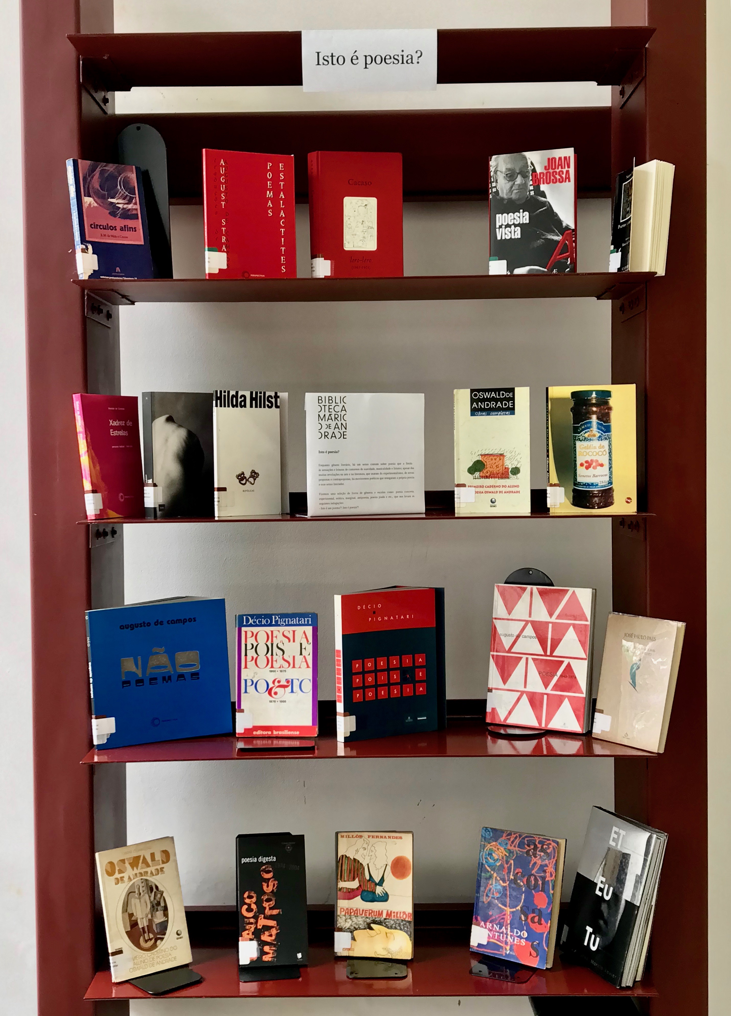 Foto de estante de 4 prateleiras com livros.