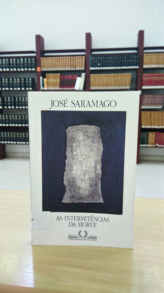 Livro com capa branca com retângulo azul preenchido por formas cinzas que se assemelham a pedras.
