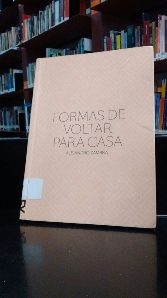 Título Formas de voltar para casa escrito na cor preta com capa na cor salmão com detalhes geométricos.