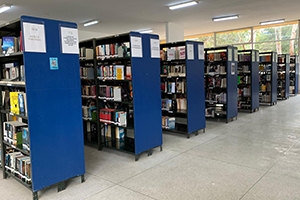 Foto das estantes azuis com livros no interior da Biblioteca Affonso Taunay