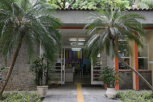 Porta de entrada da biblioteca com árvores nas laterais