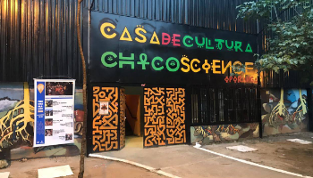 Fachada da Casa de Cultura Chico Science: parede preta com portão decorado com desenhos tribais laranjas