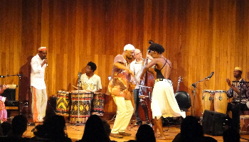 Os músicos Kolela Kabengele e Luciane Ramos Dançam ao som do Comboio no auditório da Biblioteca Mário de Andrade.