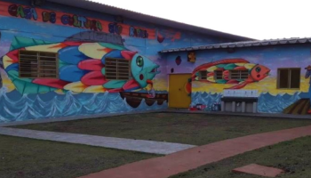 Um edifício térreo em L decorado com graffitis com desenhos de peixes coloridos