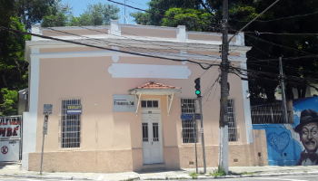 Casa de estilo colonial em cor creme, com molduras brancas.